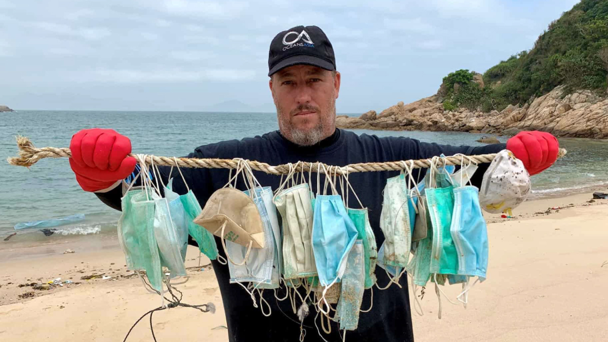 A man holds COVID-19 masks on a fishing line