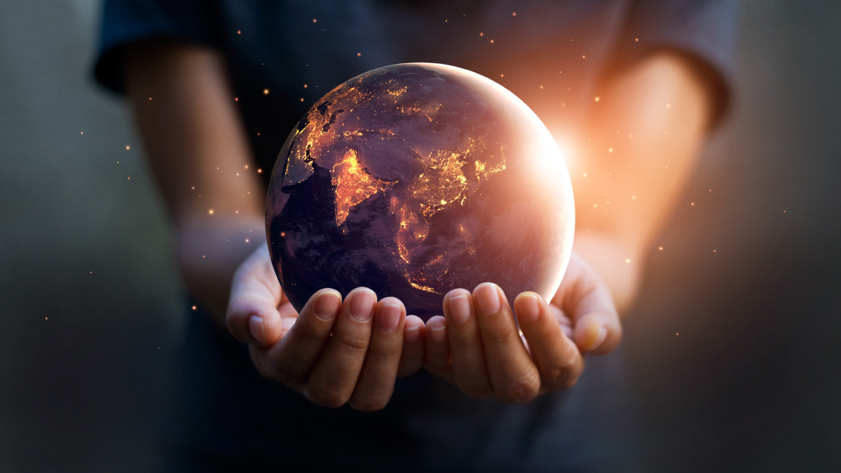 A child holds a globe in his or her hands