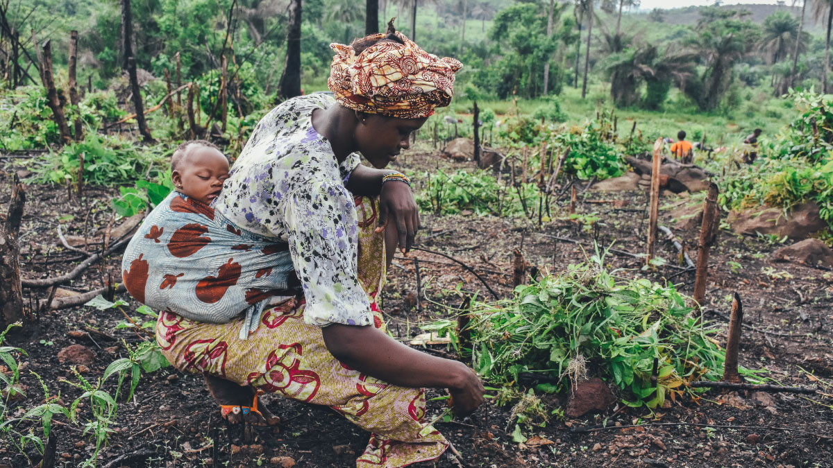 An African woman farmer with her child
