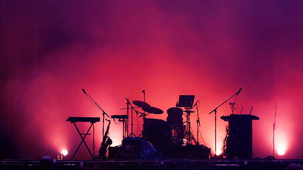 Drum kit on stage without people lit my purple hues