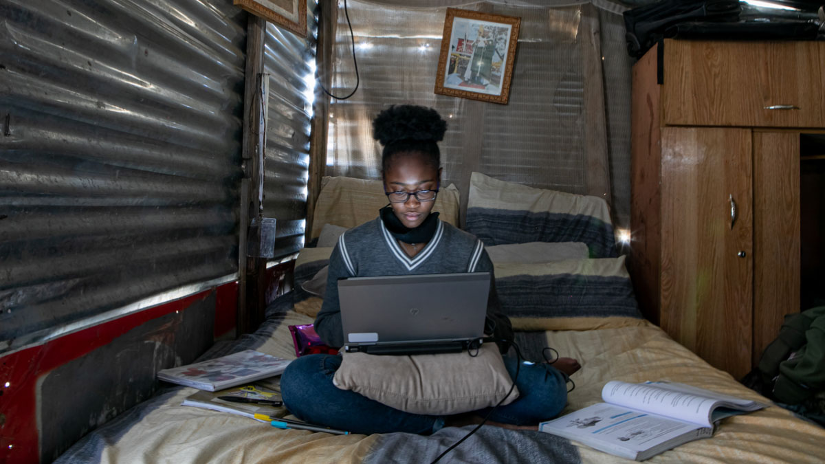 African girl studying with computer at home