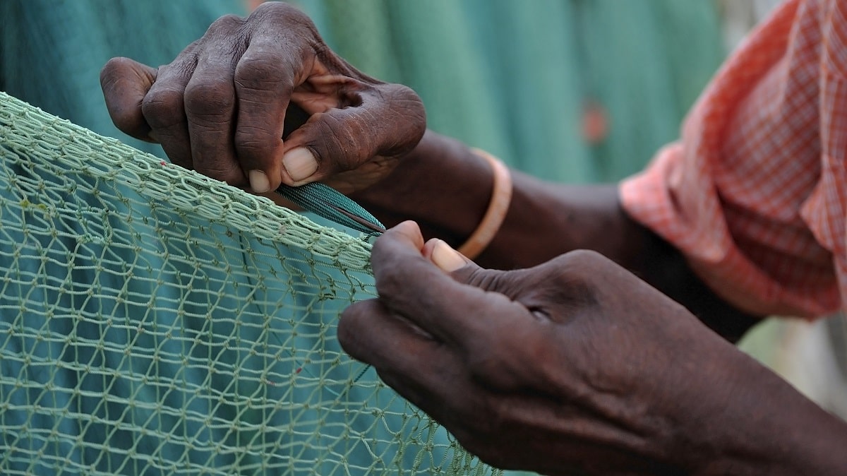 A fisherman in Saint Lucia fixes a net