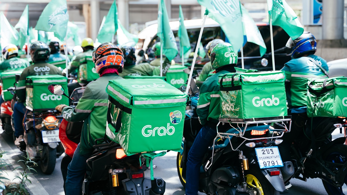 A group of Grab food delivery riders riding a motorbike doing their services.