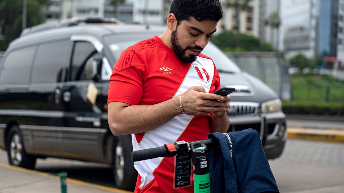 A consumer uses his mobile phone to unlock a scooter sharing rental service in Lima, Peru.