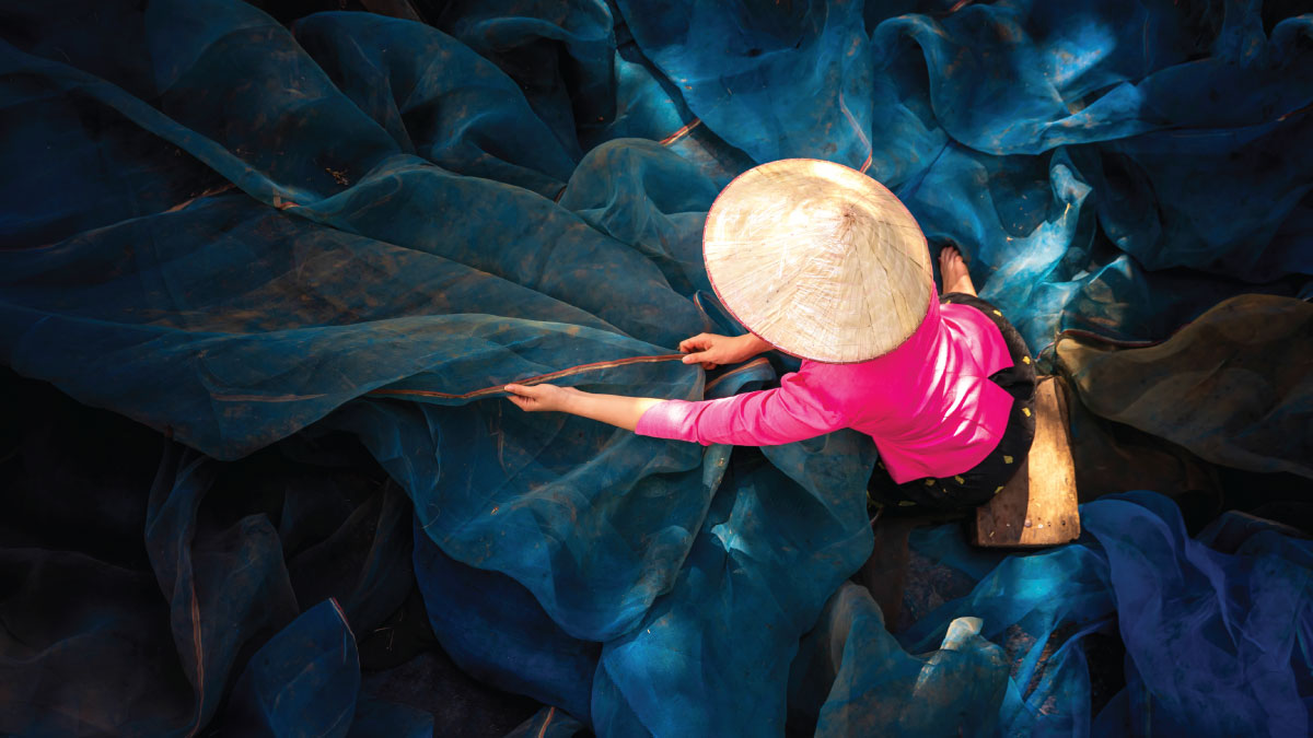 A woman repairs a fishing net