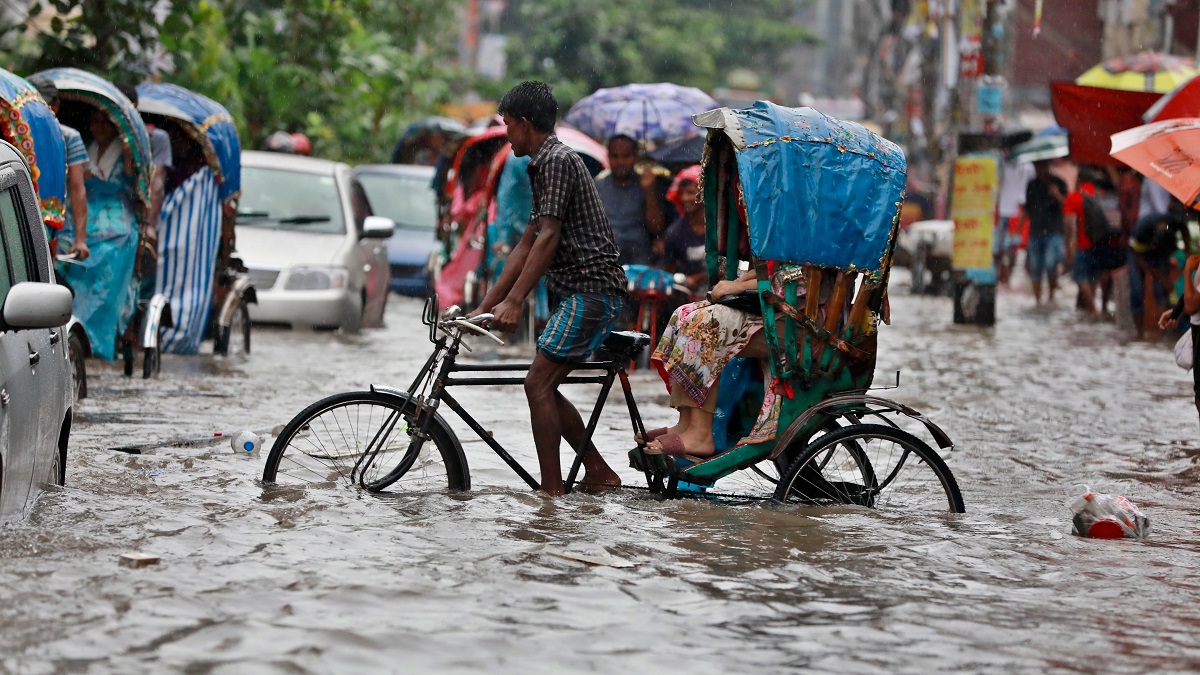 ehicles try to drive through a flooded street in Dhaka, Bangladesh.