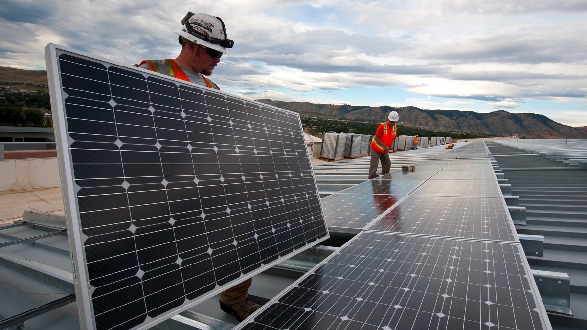 Workers install solar panels in Rio de Janeiro, Brazil