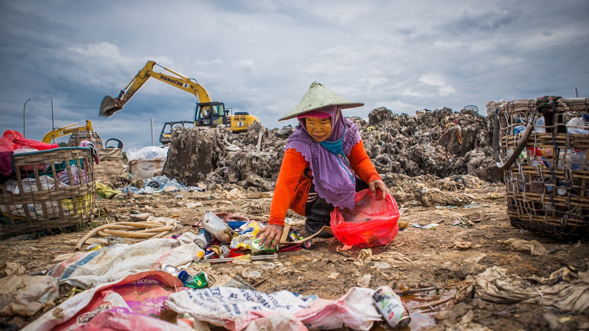 A woman sorts through trash in Indonesia