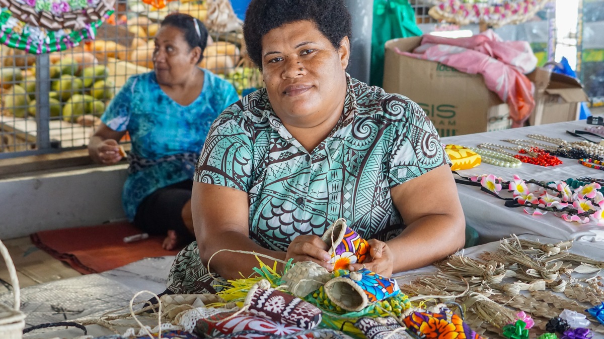 Fijian women making and selling crafts for tourists in Farmers and craft market in Fiji.
