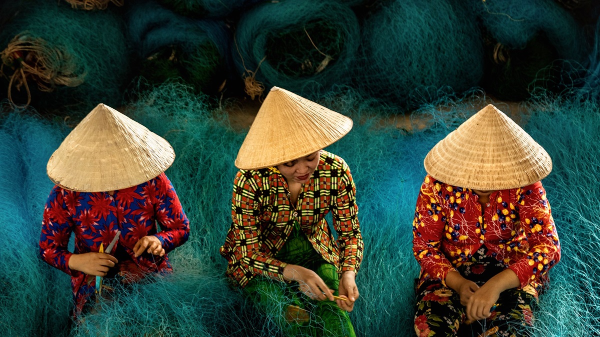 Women repair fishing nets in Bac Lieu City, Vietnam.