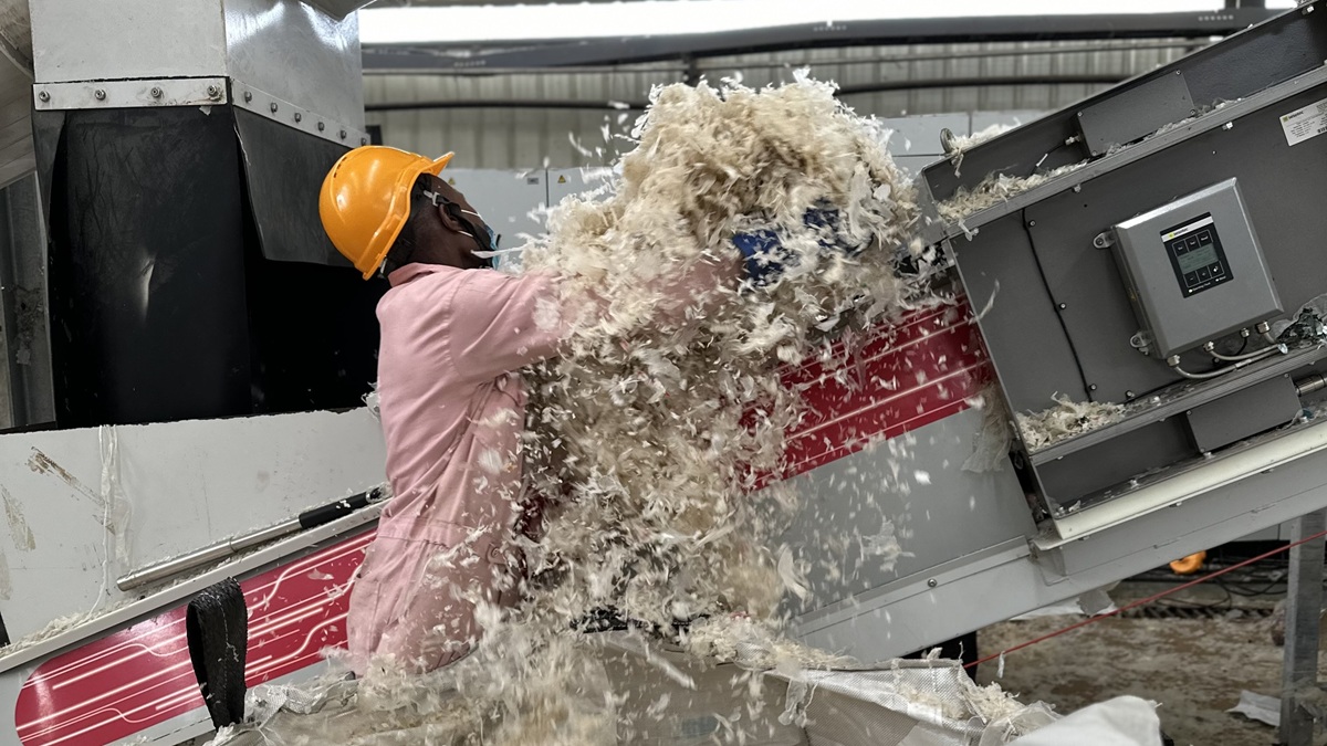 A worker handles shredded plastic on a processing line at a recycling plant in Nairobi, Kenya.