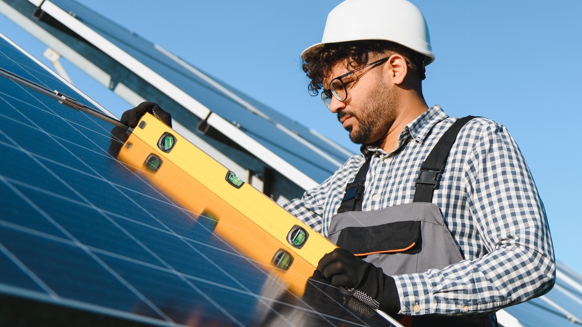 A worker installs solar panels at a photovoltaic power plant.