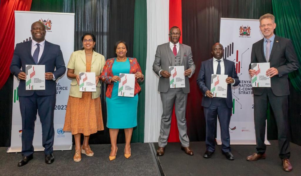 Launch of the Kenya e-commerce strategy. © GIZ | Officials with copies of the strategy during its launch in Nairobi. Left to right: Alfred K’Ombudo, Principal Secretary, State Department for Trade; Shamika N. Sirimanne, UNCTAD Director of Technology and Logistics; Rebecca Miano, Cabinet Secretary for the Ministry of Trade, Investments and Industry; Eliud Owalo, Cabinet Secretary for the Ministry of Information, Communications and The Digital Economy; John Kipchumba Tanui, Principal Secretary, State Department for ICT and Digital Economy; and Alexander Fierley, Deputy Ambassador of the Federal Republic of Germany to Kenya.