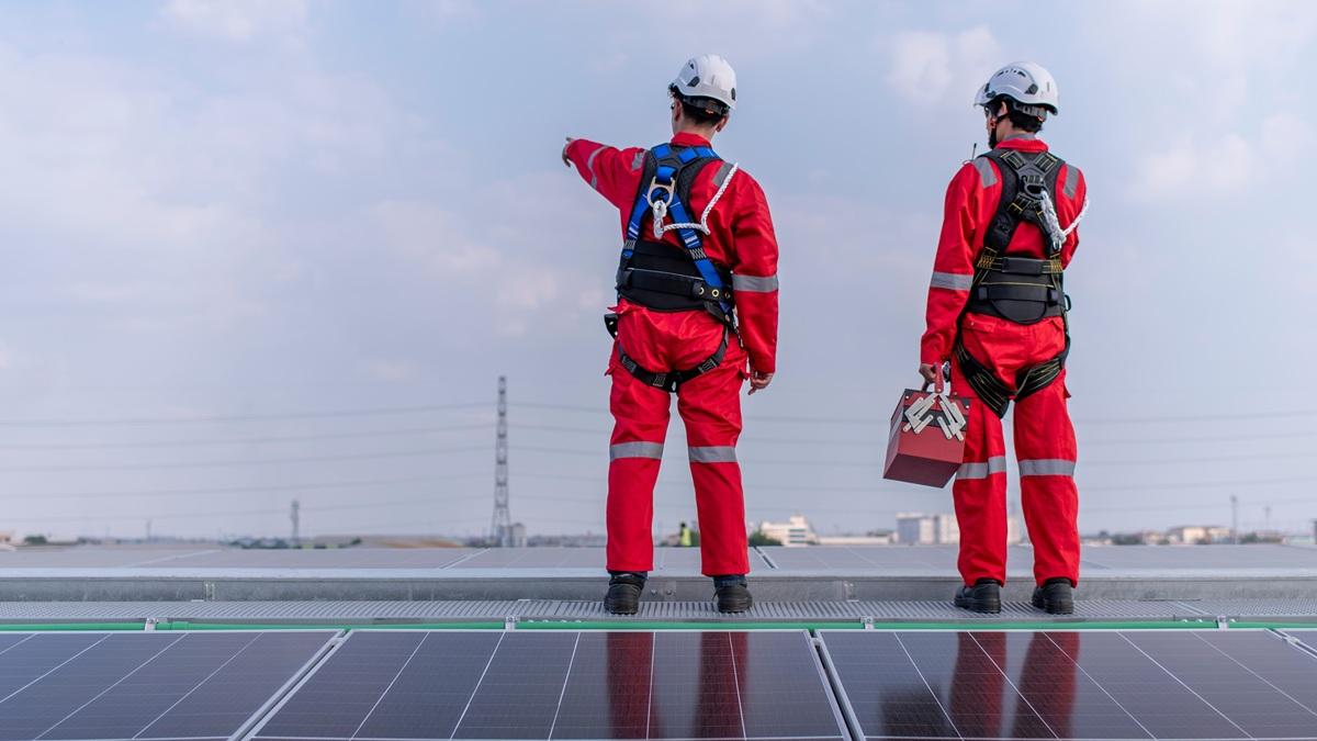 Engineers inspecting solar panels on a rooftop.