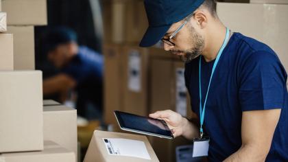 A logistics worker scans a package as part of the shipping process.