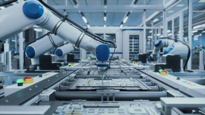 Automated robotic arms assemble circuit boards at an advanced manufacturing plant.
