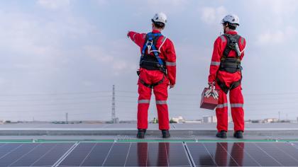 Engineers inspecting solar panels on a rooftop.
